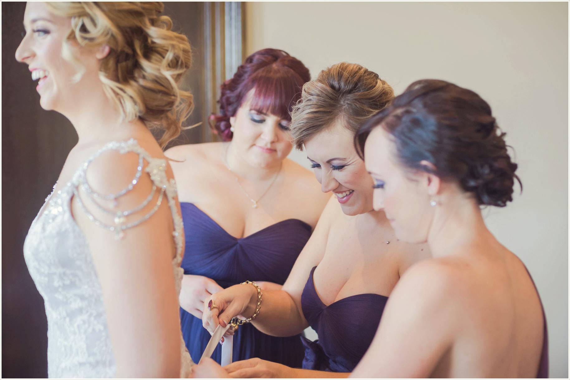 bridesmaids dressing bride